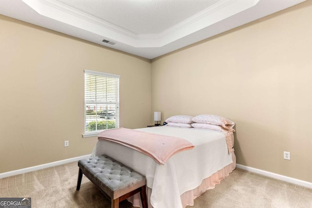 bedroom featuring ornamental molding, a raised ceiling, and carpet flooring