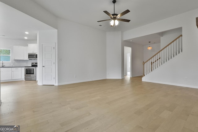 unfurnished living room with light hardwood / wood-style floors and ceiling fan