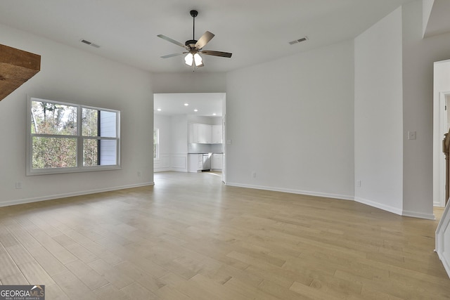 unfurnished living room featuring ceiling fan and light wood-type flooring