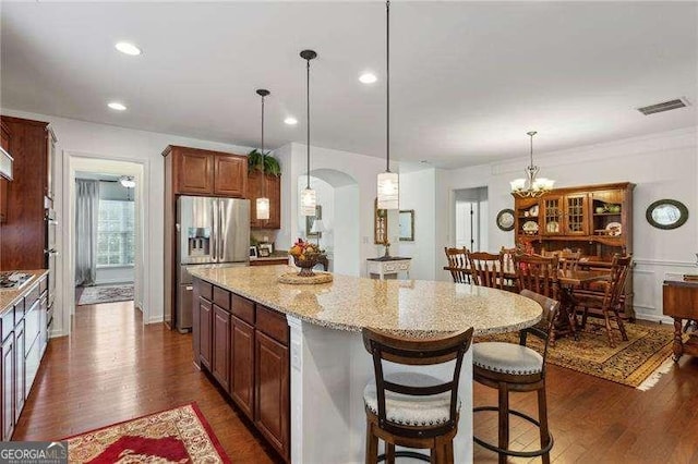 kitchen with dark hardwood / wood-style flooring, a center island, stainless steel fridge with ice dispenser, and hanging light fixtures