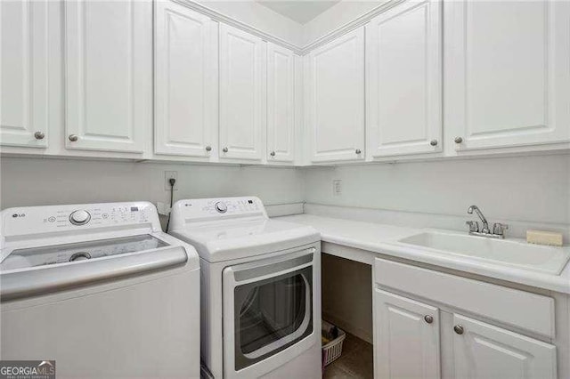 laundry area with separate washer and dryer, sink, and cabinets