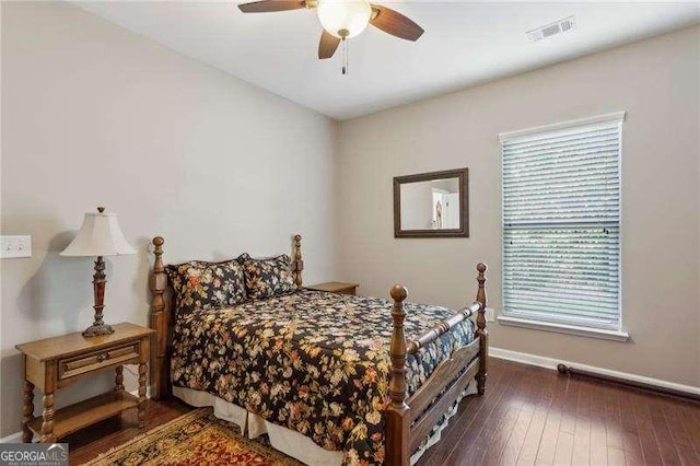 bedroom with multiple windows, dark wood-type flooring, and ceiling fan