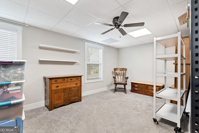 sitting room featuring ceiling fan, a paneled ceiling, and light colored carpet