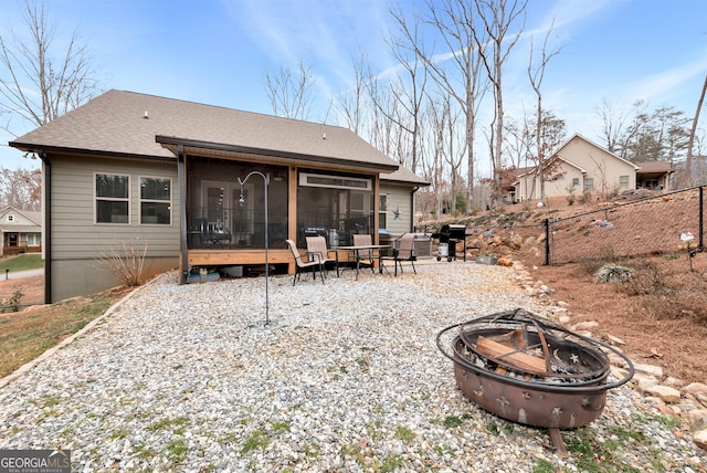 back of house featuring a sunroom and a fire pit