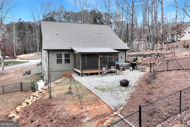 back of house featuring a sunroom and a fire pit