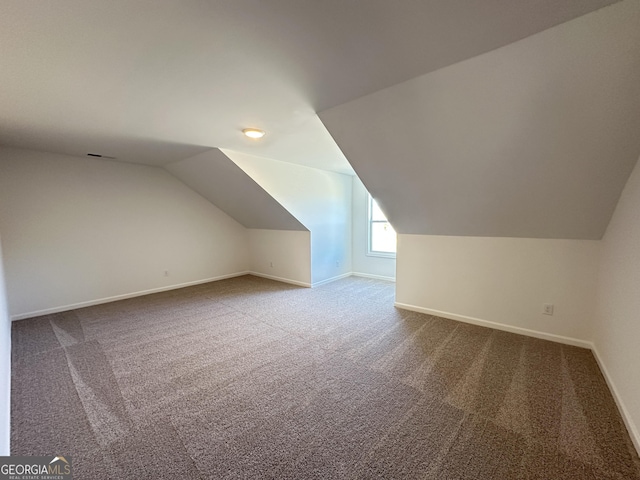 bonus room featuring vaulted ceiling and carpet