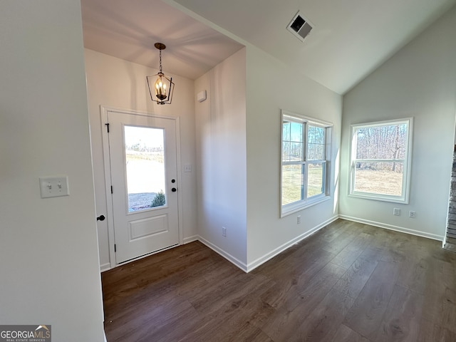 foyer with dark hardwood / wood-style floors, a chandelier, and vaulted ceiling