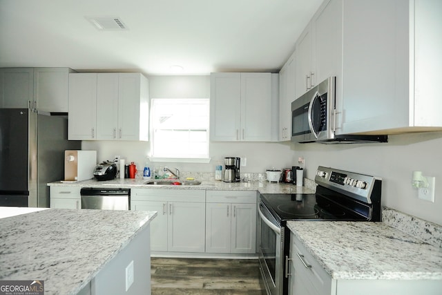 kitchen featuring white cabinetry, appliances with stainless steel finishes, sink, and dark hardwood / wood-style floors