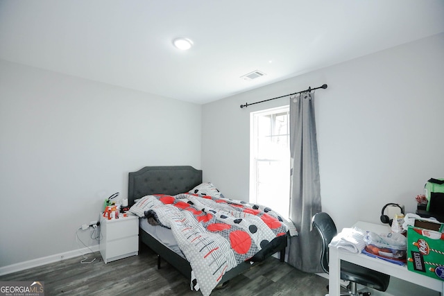 bedroom with dark hardwood / wood-style flooring