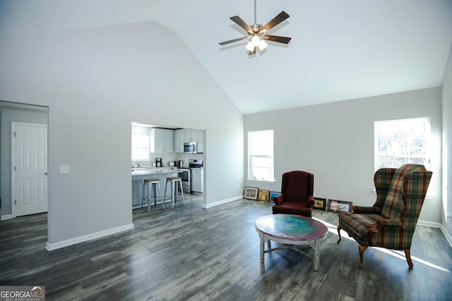 living area featuring dark wood-type flooring, ceiling fan, and high vaulted ceiling