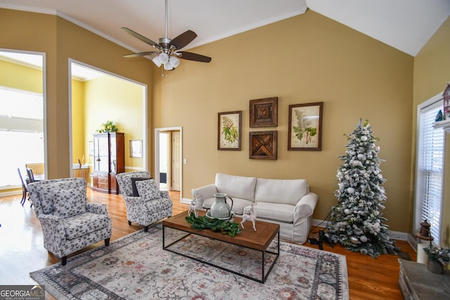 living room with crown molding, ceiling fan, high vaulted ceiling, and hardwood / wood-style floors