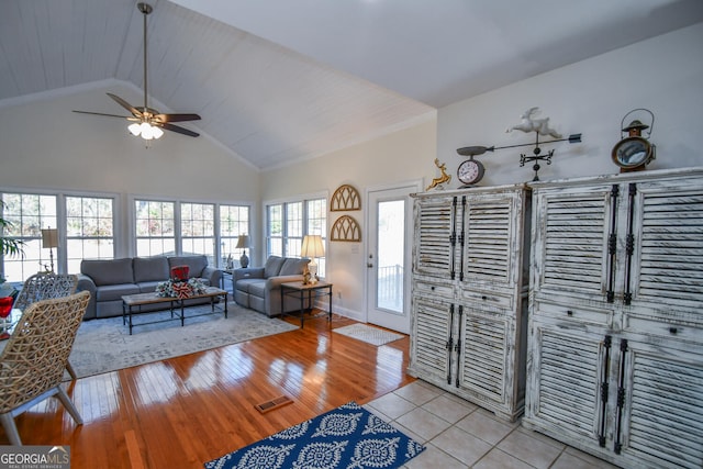 living room featuring high vaulted ceiling, light tile patterned floors, and ceiling fan