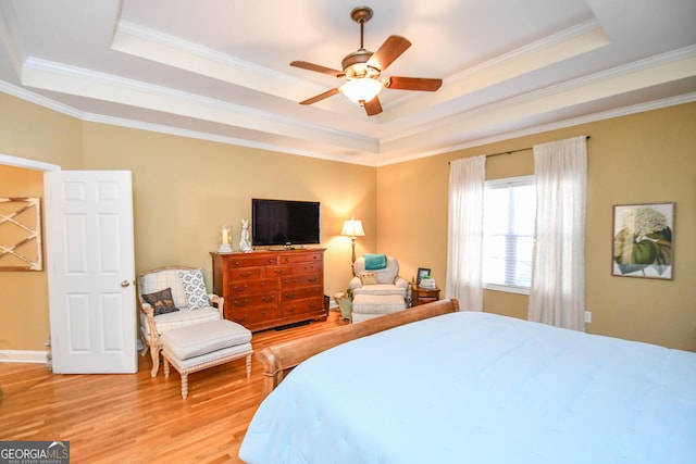 bedroom with ornamental molding, a raised ceiling, and ceiling fan