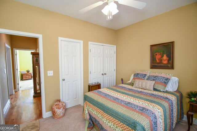 carpeted bedroom with ceiling fan and a closet