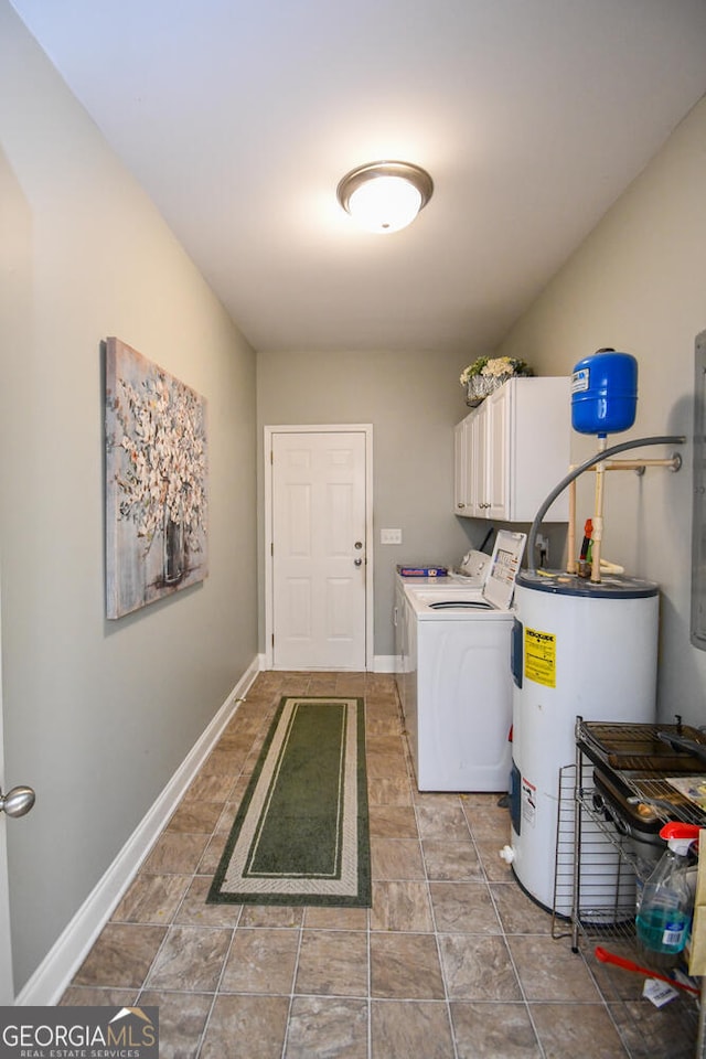 clothes washing area featuring cabinets, electric water heater, and washer and clothes dryer