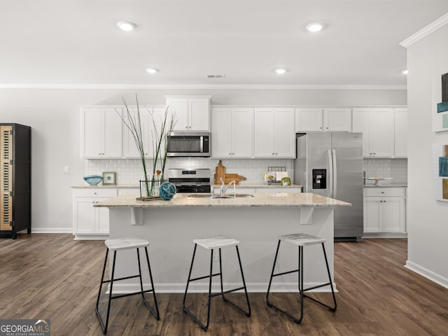 kitchen featuring sink, an island with sink, white cabinets, and appliances with stainless steel finishes