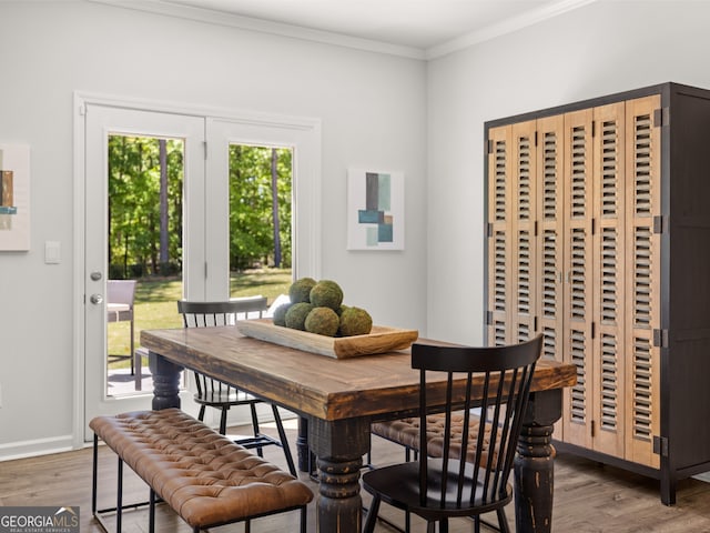 dining area with hardwood / wood-style flooring and ornamental molding