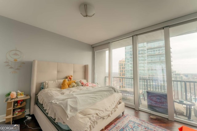 bedroom featuring floor to ceiling windows, dark wood-type flooring, and access to outside