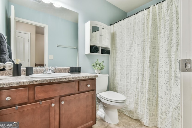 bathroom with tile patterned flooring, vanity, and toilet