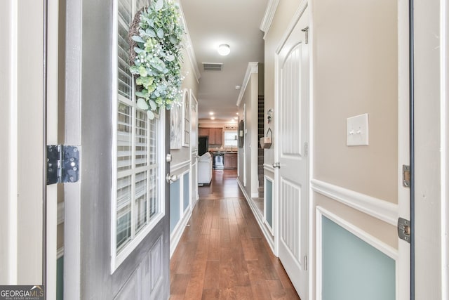 hall with ornamental molding and dark hardwood / wood-style floors