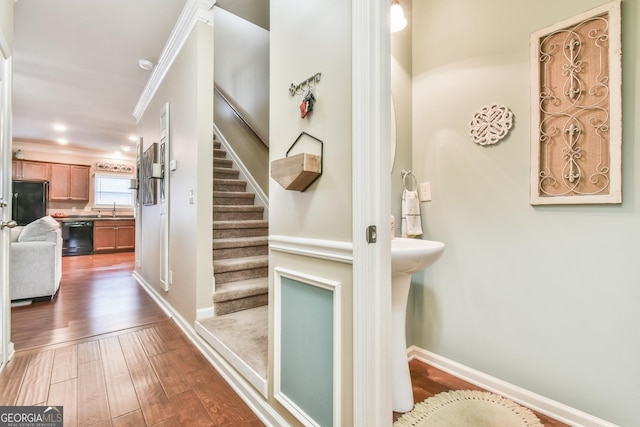 stairs featuring sink, crown molding, and wood-type flooring