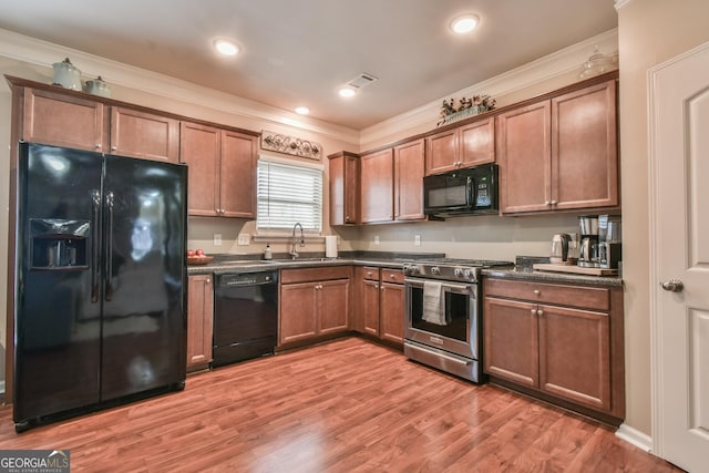 kitchen featuring ornamental molding, sink, hardwood / wood-style floors, and black appliances