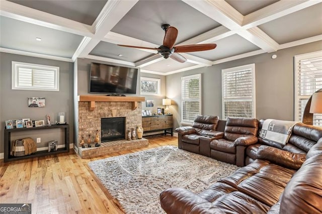 living room with a fireplace, ornamental molding, coffered ceiling, and light wood-type flooring