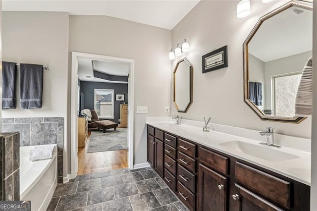 bathroom with vanity and a tub