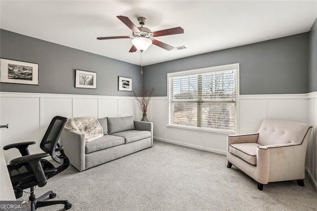 carpeted office space featuring ceiling fan