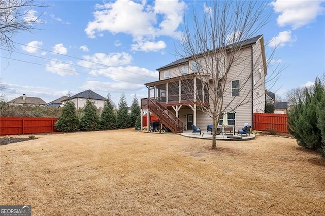 rear view of house with a patio area, a sunroom, and a lawn