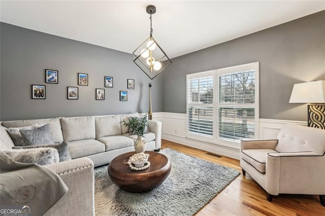 living room featuring light hardwood / wood-style flooring and a notable chandelier