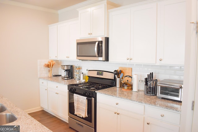 kitchen featuring light stone countertops, white cabinets, and appliances with stainless steel finishes