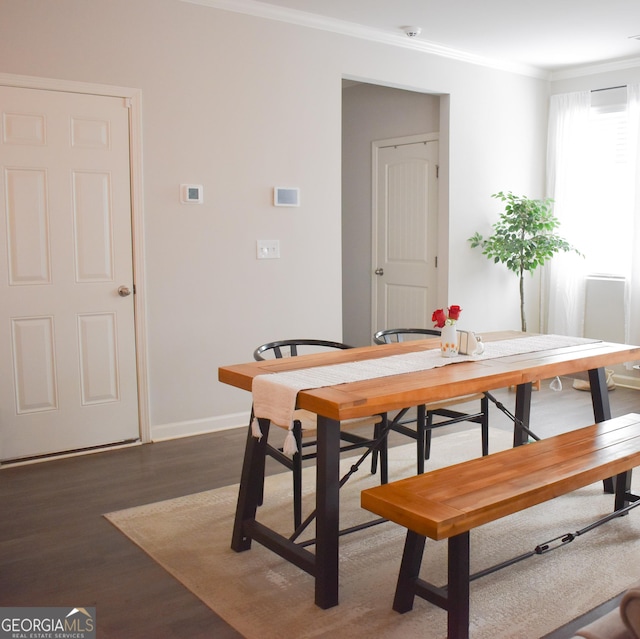 dining room with dark hardwood / wood-style flooring and crown molding