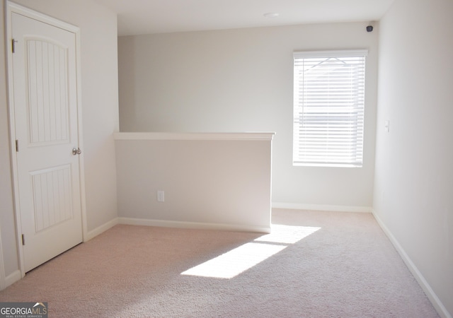 unfurnished room featuring light colored carpet