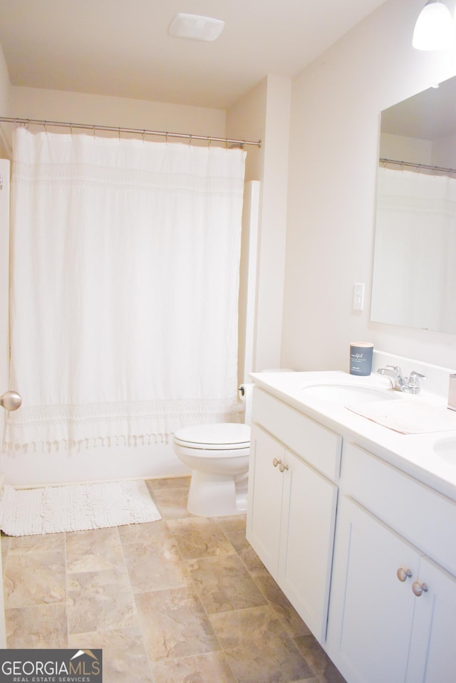 bathroom with vanity, curtained shower, and toilet