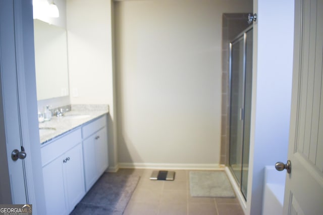 bathroom featuring tile patterned flooring, vanity, and a shower with shower door