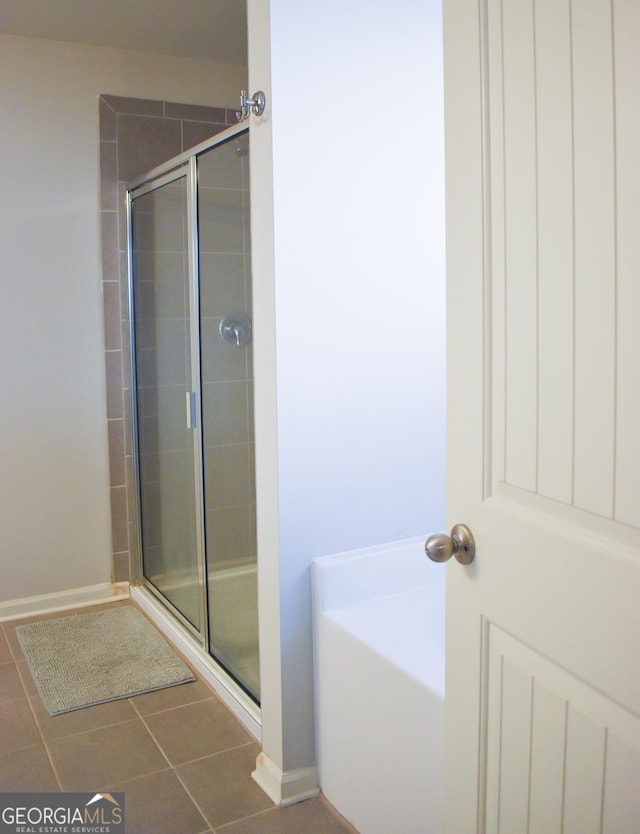 bathroom with tile patterned floors and walk in shower