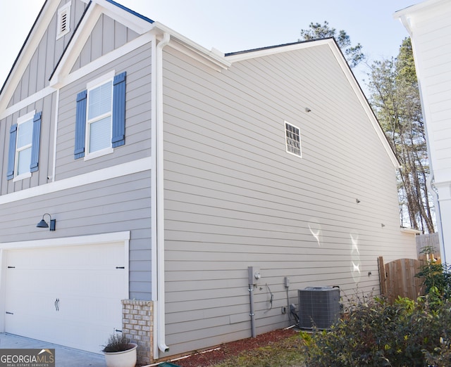 view of side of property featuring cooling unit and a garage