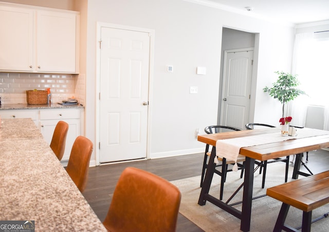 dining room featuring dark wood-type flooring and crown molding