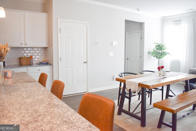 dining room featuring ornamental molding and dark hardwood / wood-style flooring