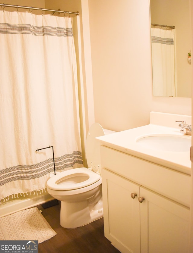 bathroom with vanity, wood-type flooring, and toilet