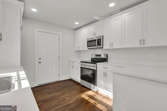 kitchen with stainless steel appliances, sink, white cabinets, and dark hardwood / wood-style flooring