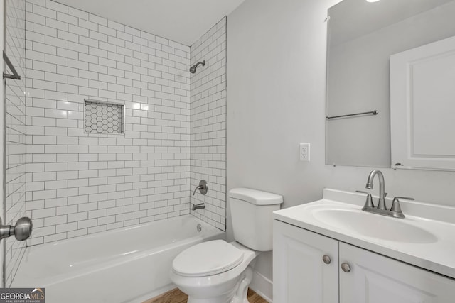 full bathroom featuring tiled shower / bath combo, vanity, and toilet