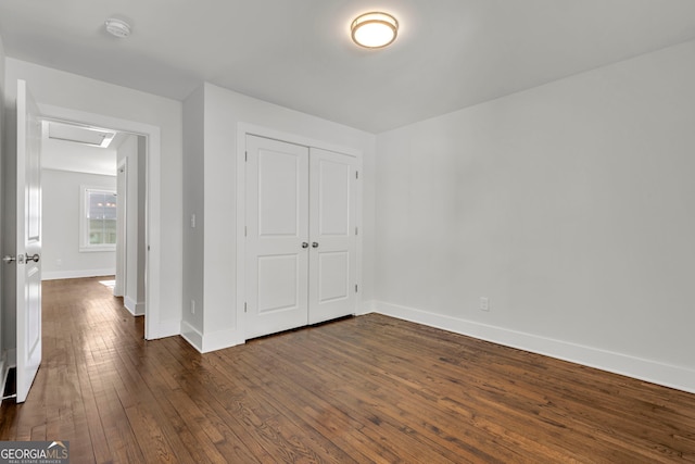 unfurnished bedroom featuring dark wood-type flooring and a closet