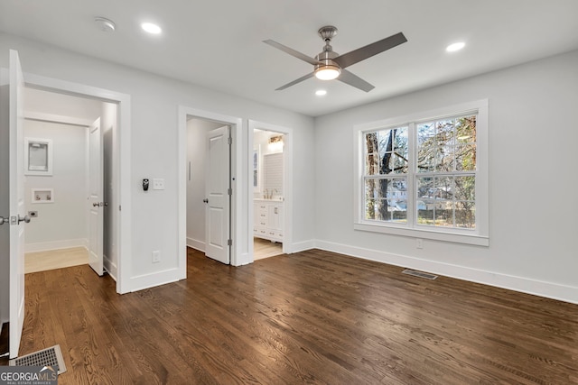 unfurnished bedroom featuring dark hardwood / wood-style flooring, connected bathroom, and ceiling fan