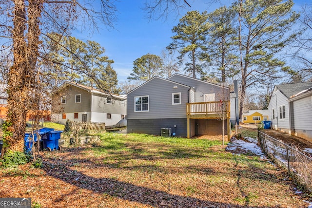 rear view of property with central AC and a lawn