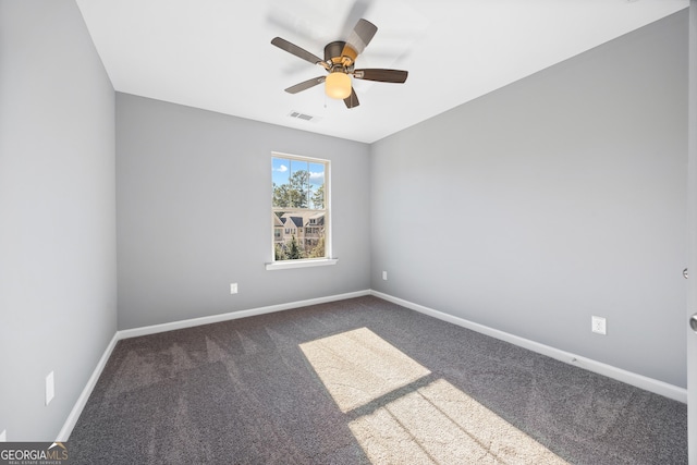 empty room featuring ceiling fan and carpet