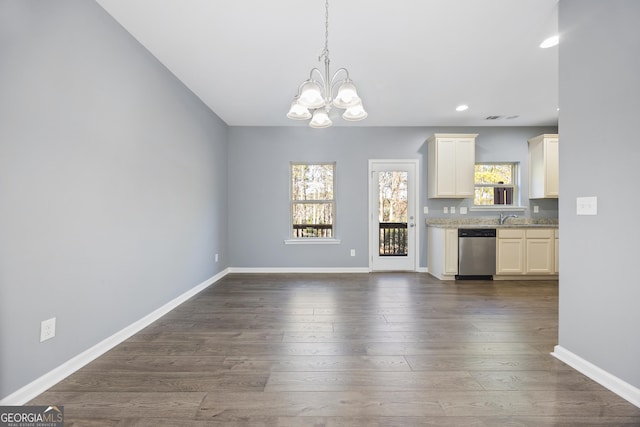 unfurnished living room with dark wood-type flooring, a chandelier, and sink