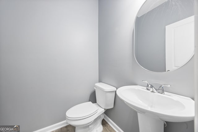 bathroom with sink, hardwood / wood-style flooring, and toilet