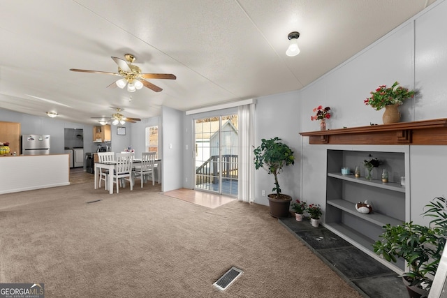 carpeted living room with vaulted ceiling and built in shelves